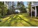 Grassy backyard showing a small blue shed and views of the home's deck and lush trees at 2142 Graystone Pkwy, Grayson, GA 30017