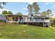 Lush backyard view of blue house with screened porch, deck, and mature landscaping at 2142 Graystone Pkwy, Grayson, GA 30017