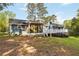 Expansive backyard view featuring a blue house, screened porch, deck, and mature trees at 2142 Graystone Pkwy, Grayson, GA 30017