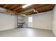 Unfinished basement with painted concrete floor, exposed wood rafters, and access door to the backyard at 2142 Graystone Pkwy, Grayson, GA 30017