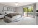 This bedroom features a large bed, neutral colors, and a sliding glass door to a private balcony at 2142 Graystone Pkwy, Grayson, GA 30017