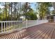 Spacious wooden deck with white railings and treed backyard view, offering ample space for outdoor relaxation at 2142 Graystone Pkwy, Grayson, GA 30017