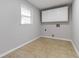 Functional laundry room with white cabinets, neutral walls, and tile flooring at 2142 Graystone Pkwy, Grayson, GA 30017