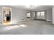 Spacious living room with gray carpet, light walls, and views into the kitchen and front entry at 2142 Graystone Pkwy, Grayson, GA 30017