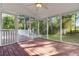 Screened porch with wood flooring and views of the surrounding yard and foliage at 2142 Graystone Pkwy, Grayson, GA 30017