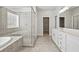 Luxurious bathroom featuring double vanities, a glass-enclosed shower, and stylish gray tile at 3293 Lions Ruby Ln, Atlanta, GA 30349