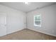 Neutral bedroom featuring a single window with blinds and plush carpeting at 3293 Lions Ruby Ln, Atlanta, GA 30349