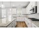Modern kitchen featuring white cabinets, granite countertops, stainless steel appliances and hardwood floors at 3293 Lions Ruby Ln, Atlanta, GA 30349