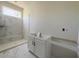 Bathroom with marble shower, white cabinetry, and natural light at 4085 Sierra Vista Cir, Cumming, GA 30040