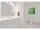 Clean bathroom featuring a white vanity, toilet, tiled shower and a bright window at 475 Nottingham Dr, Marietta, GA 30066