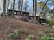 Charming brown home with stone base and colorful flower landscaping on a wooded lot at 475 Nottingham Dr, Marietta, GA 30066