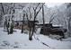 Snowy view of home exterior with a stone facade and stairs leading to the front entrance at 475 Nottingham Dr, Marietta, GA 30066
