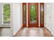 A foyer with a beautiful glass paneled front door and wood floors, next to a bright window at 475 Nottingham Dr, Marietta, GA 30066