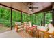 The staged screened porch has a seating area, ceiling fan, and a great view of the woods at 475 Nottingham Dr, Marietta, GA 30066