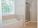 Bathroom featuring separate shower and tub with window and beige tile at 663 Prada Ct, Lawrenceville, GA 30043