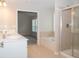 Bright bathroom showcasing double sinks, soaking tub and glass-enclosed shower at 663 Prada Ct, Lawrenceville, GA 30043