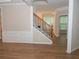 Hallway features new flooring, staircase with wood and metal railing and wainscoting at 663 Prada Ct, Lawrenceville, GA 30043