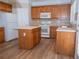 Spacious kitchen with wooden cabinets, white appliances, an island and stylish tile backsplash at 663 Prada Ct, Lawrenceville, GA 30043