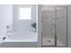 Bright bathroom featuring a soaking tub with chrome fixtures and glass-enclosed shower at 2010 Vidalia Ct, Dacula, GA 30019
