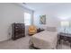 Comfortable bedroom with a soft color palette, dresser, chair and a sunny window at 2010 Vidalia Ct, Dacula, GA 30019