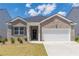 Charming brick home featuring a two-car garage, well-maintained lawn, and inviting entrance at 2010 Vidalia Ct, Dacula, GA 30019