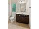 Well-lit bathroom features vanity with dark cabinets, a white sink, and a large mirror at 2020 Jardin Ct, Alpharetta, GA 30022