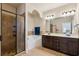 Luxurious bathroom with a glass shower, a soaking tub, double vanity, and elegant lighting at 2020 Jardin Ct, Alpharetta, GA 30022