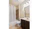 Bathroom featuring a shower-tub combo, dark wood vanity, and decorative lighting at 2020 Jardin Ct, Alpharetta, GA 30022
