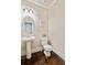 Cozy powder room featuring a pedestal sink, wood flooring, and contemporary fixtures at 2020 Jardin Ct, Alpharetta, GA 30022