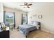 Comfortable bedroom with carpeted floors, two windows with green views, and a modern ceiling fan at 2020 Jardin Ct, Alpharetta, GA 30022