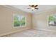 Comfortable bedroom with natural light from two windows and neutral carpeting at 2020 Jardin Ct, Alpharetta, GA 30022