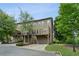 Exterior view of a townhome with a balcony and garage nestled among mature trees at 2020 Jardin Ct, Alpharetta, GA 30022