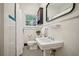 Classic bathroom with white tile, black and white floor, and pedestal sink at 615 Sycamore Dr, Decatur, GA 30030