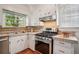 Well-lit kitchen features tile counters, a stainless steel range, and hardwood flooring at 615 Sycamore Dr, Decatur, GA 30030