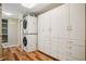 Bright laundry room with stackable washer/dryer and ample storage cabinets at 615 Sycamore Dr, Decatur, GA 30030