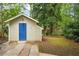 Charming outbuilding with a bright blue door, adding character to the landscaped backyard at 615 Sycamore Dr, Decatur, GA 30030