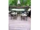 Deck with outdoor dining set featuring a glass table and four chairs with cushions at 7324 Bridlewood Ct, Jonesboro, GA 30236