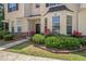 Inviting townhome entrance featuring a well-kept lawn, vibrant rose bushes, and modern black door at 7324 Bridlewood Ct, Jonesboro, GA 30236
