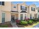 Inviting townhome entrance featuring a well-kept lawn, vibrant rose bushes, and modern black door at 7324 Bridlewood Ct, Jonesboro, GA 30236