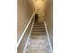 Carpeted staircase with white railings, well lit, and neutral colors at 7324 Bridlewood Ct, Jonesboro, GA 30236
