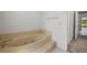 Bathroom featuring an elevated soaking tub, tile flooring, and a connecting door at 1440 Northwold Dr, Atlanta, GA 30350
