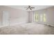 Spacious bedroom featuring carpeted floors, three windows, ceiling fan and white trim at 1440 Northwold Dr, Atlanta, GA 30350