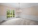 Light-filled dining room with classic wainscoting, chandelier, and large picture window at 1440 Northwold Dr, Atlanta, GA 30350