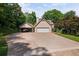 Exterior view of home with a driveway, garage, carport, and mature trees at 1440 Northwold Dr, Atlanta, GA 30350