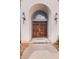 A front door with archway, sidelights, and coach lights makes a charming entrance at 1440 Northwold Dr, Atlanta, GA 30350