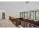 Second story hallway with wood railing and large windows overlooking the exterior at 1440 Northwold Dr, Atlanta, GA 30350