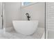 Modern bathroom featuring a standalone tub with black faucet and marble tile flooring at 1576 Hawthorne Se Ave, Smyrna, GA 30080