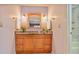 Bathroom vanity with wood cabinet, granite countertop, decorative mirror, and modern lighting fixtures at 59 Saint Claire Ne Ln, Atlanta, GA 30324