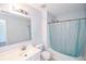 A bathroom has a white vanity, a large mirror, and a tub/shower combination with a blue curtain at 2201 Landing Walk Dr, Duluth, GA 30097