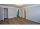 A bright bedroom features crown molding, a modern light fixture, and wood floors, with a view of the closet at 2201 Landing Walk Dr, Duluth, GA 30097